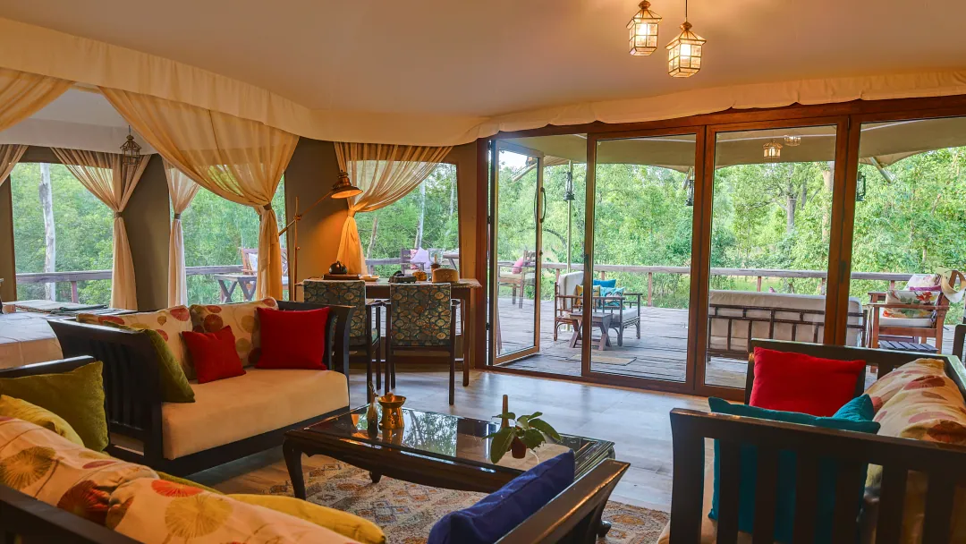 The sitting room of the Chief's Tent with lanterns overhead and glass doors to the deck