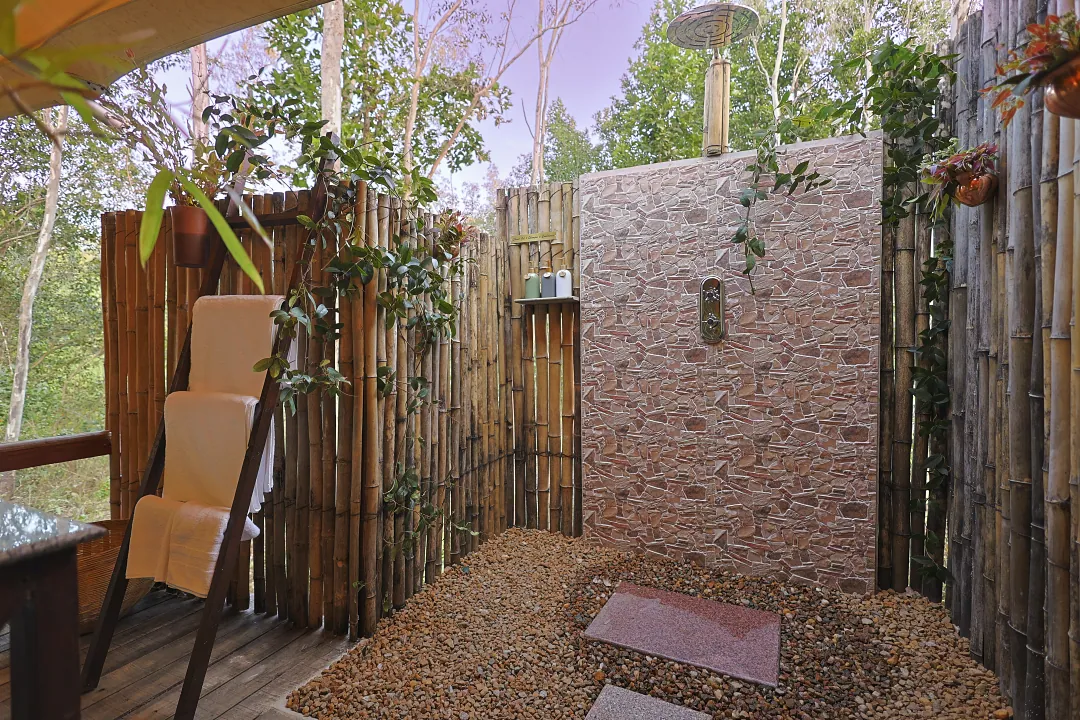The King's Tent's outdoor shower screened with bamboo and stone